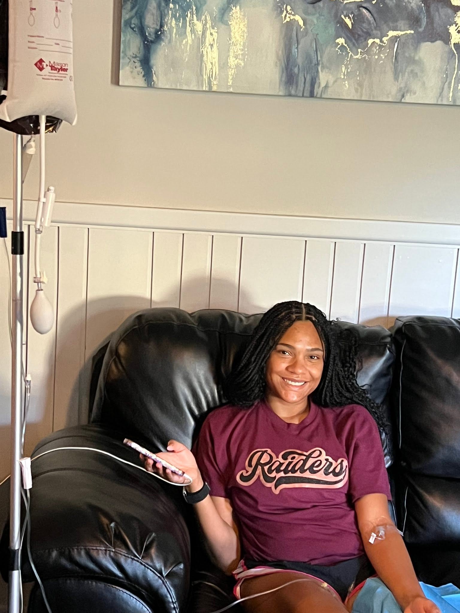 Client receiving an IV drip in a Texas Tech tee